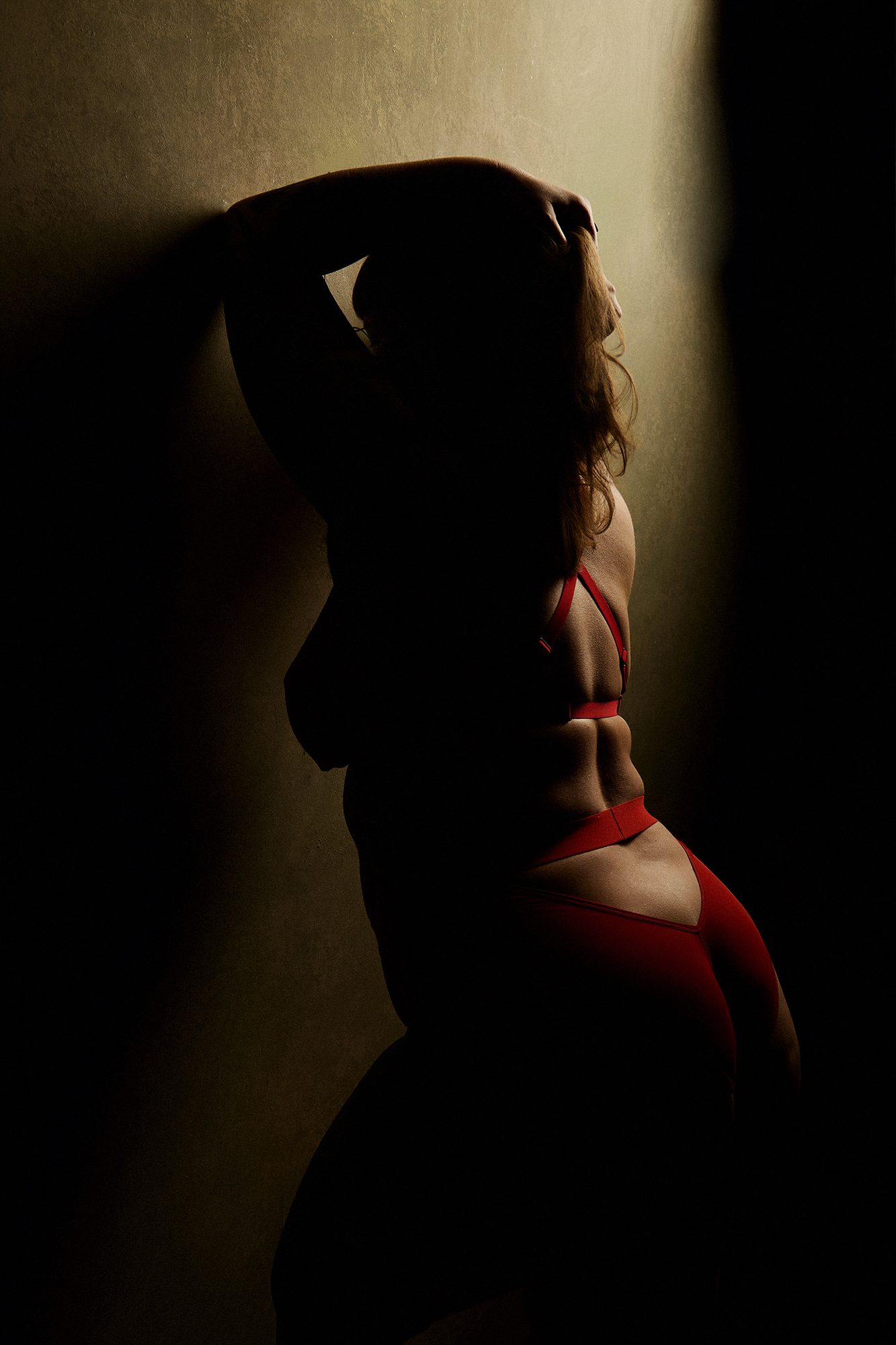 Sensuele boudoirshoot met tattoos in warm zijlicht in de studio